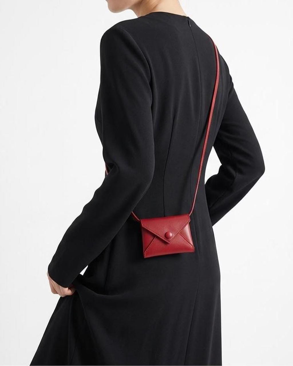 A model wearing a black long-sleeve dress is shown from the back, wearing a small red envelope-style crossbody bag with a thin red strap.